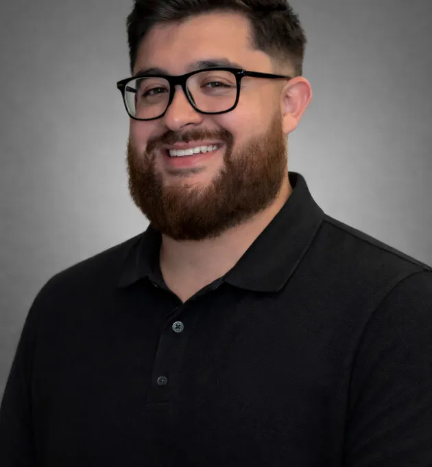 Dental technician precision-crafting a prosthetic at a digital design workstation